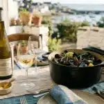 Table avec moules, vin blanc et vue sur la mer